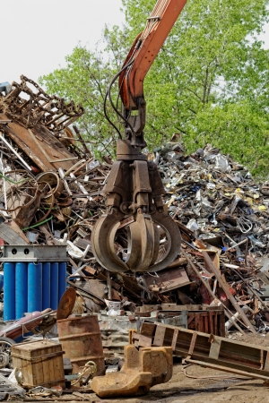 inustrial machine with scrap metal grapple in front of scrap ironの写真素材
