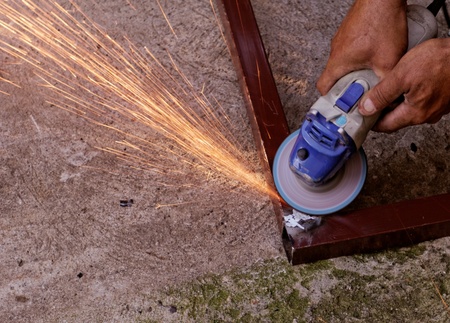 Metal buffing with hand grinder. Sparks while grinding iron.