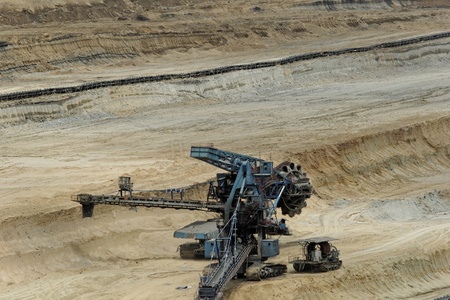 Coal mining in an open pit with huge industrial machineの写真素材