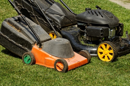 two lawnmower in the garden lawn the grass  fuel and electricity 