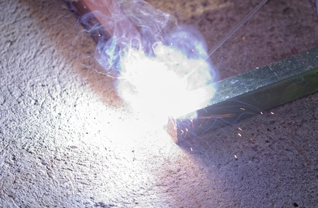 Iron welding with bright light and smoke at manufacturingの写真素材