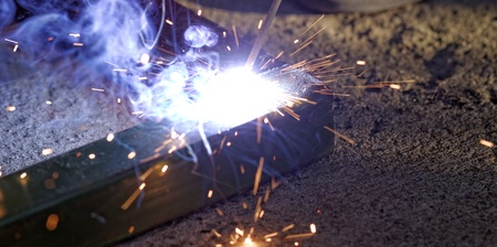 Iron welding with bright light and smoke at manufacturing
