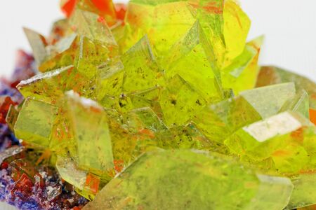 Close up picture about a crystal with topaz color on white background (yellow crystal)