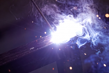 Iron welding with bright light and smoke at manufacturingの写真素材