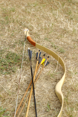 color archery arrows and bow in nature on the groundの写真素材