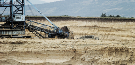 Coal mining in an open pit with huge industrial machineの写真素材