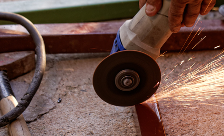 Metal sawing with hand grinder. Sparks while grinding iron.の写真素材