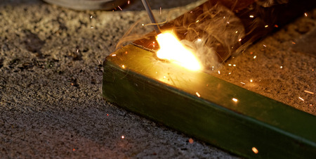 Iron welding with bright light and smoke at manufacturingの写真素材