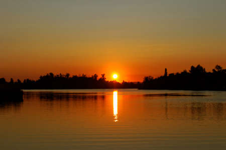 Colorful sunset over tranquil water surface.の写真素材