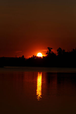 Colorful sunset over tranquil water surface.の写真素材