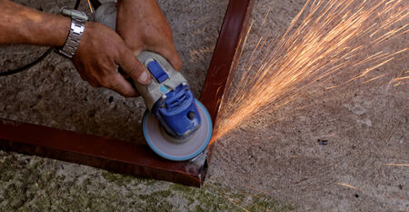 Metal buffing with hand grinder. Sparks while grinding iron.の写真素材