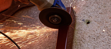 Metal sawing with hand grinder. Sparks while grinding iron.の写真素材