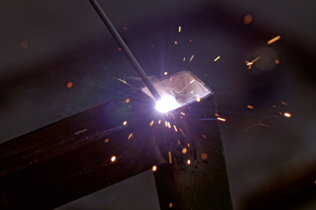 Iron welding with bright light and smoke at manufacturingの写真素材