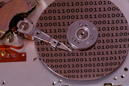 Internals of a computer harddrive with binary number reflections (HDD, winchester)の写真素材
