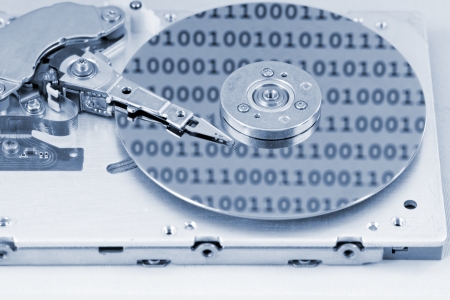 Internals of a computer harddrive with binary number reflections with blue colors (HDD, winchester)の写真素材