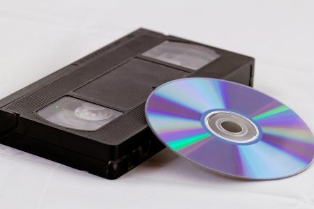 VHS video tape and DVD disk (analog digital) on white backgroundの写真素材