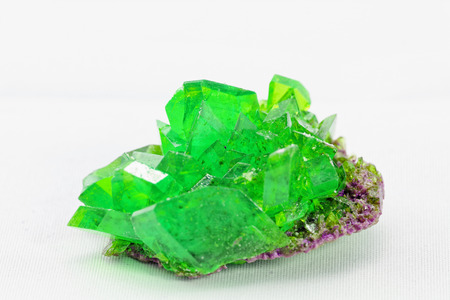 Close up picture about a crystal with emerald color on white background (green crystal)の写真素材