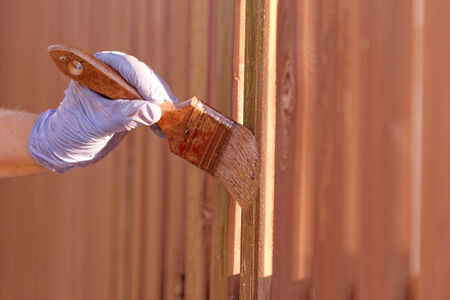 planks fence dyeing with brown paint and brushの写真素材