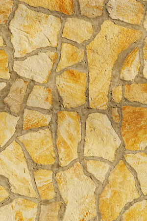 Background of a large stone wall texture (yellow)の写真素材