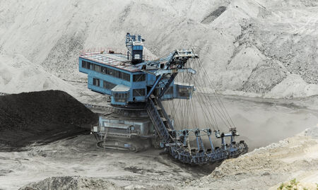 Coal mining in an open pit with huge industrial machineの写真素材