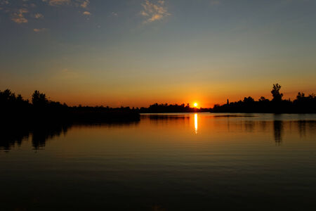 Colorful sunset over tranquil water surface.の写真素材