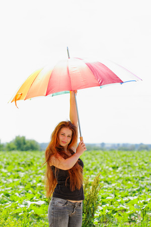 beautiful young girl with rainbow colored umbrellaの写真素材