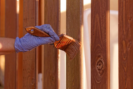planks fence dyeing with brown paint and brushの写真素材