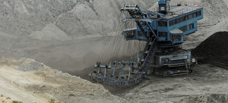 Coal mining in an open pit with huge industrial machineの写真素材