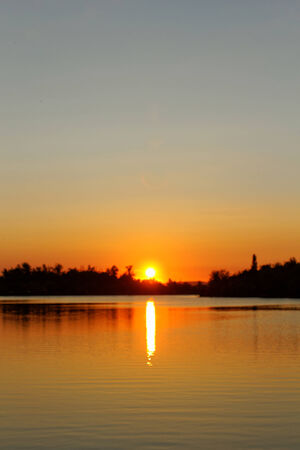 Colorful sunset over tranquil water surface.の写真素材