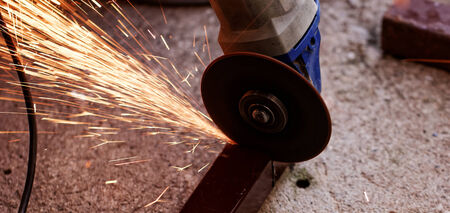 Metal sawing with hand grinder. Sparks while grinding iron.の写真素材