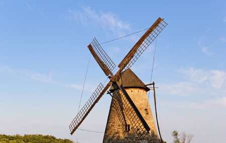 Old wooden windmill against the blue skyの写真素材