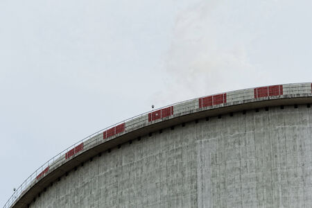 The top of the power plant cooling tower, painted white with redの写真素材