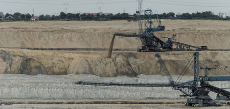 Coal mining in an open pit with huge industrial machineの写真素材