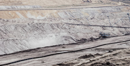 Coal mining in an open pit with huge industrial machineの写真素材