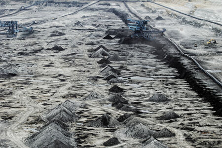 Coal mining in an open pit with huge industrial machineの写真素材