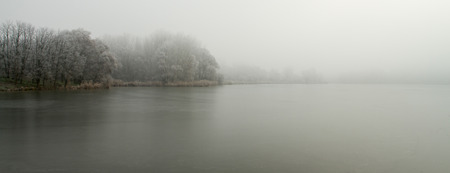 Photo of a foggy morning over the lakeの写真素材