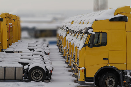 Landscape lot of yellow snowy trucksの写真素材