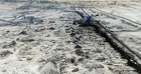 Coal mining in an open pit with huge industrial machineの写真素材
