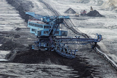 Coal mining in an open pit with huge industrial machineの写真素材