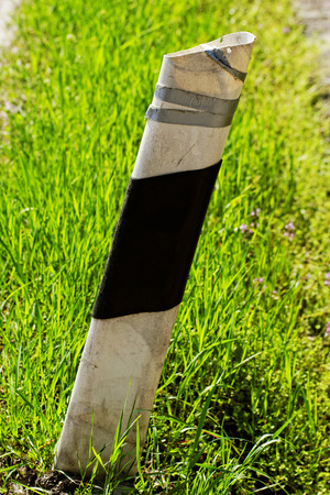 An old damaged column in the green grassの写真素材