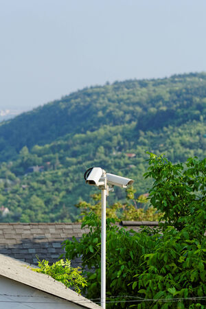 Two surveillance camera in front of the hill