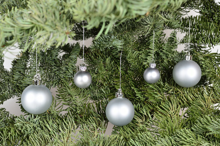 Five silver christmas balls on a green backgroundの写真素材