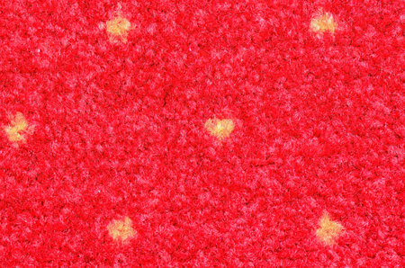 Red synthetic fiber carpet with yellow dotsの写真素材