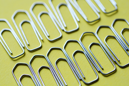 Close up of metal paperclips on yellow backgroundの写真素材
