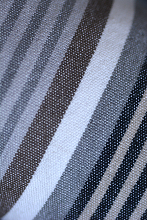 Detail of striped textile in black, yellow, gray, brown and whiteの写真素材