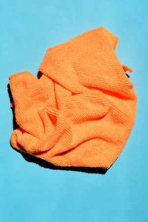 Orange microfiber cloth on blue paper backgroundの写真素材