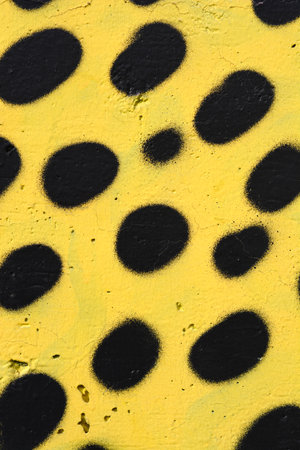 Detail of a yellow wall with black spotsの写真素材