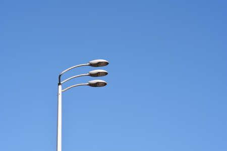 Roadway lamps against blue sky