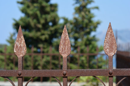 Close-up detail of a rusty metal fence with spikesの写真素材
