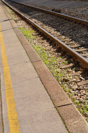 Detail of a train station platform and train tracksの写真素材